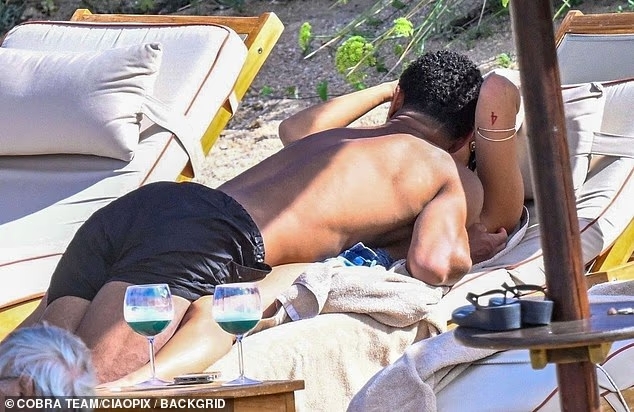 彩经网-邮报披露：贝林厄姆与伴侣撒丁岛甜蜜度假，躺椅热吻尽显亲密